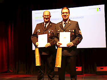 Die beiden Feuerwehrleute in Uniform mit ihren Urkunden