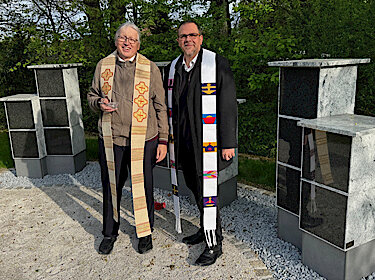 Die beiden Pfarrer stehen vor den Urnennischen. Die beiden Pfarrer stehen vor den Urnennischen.