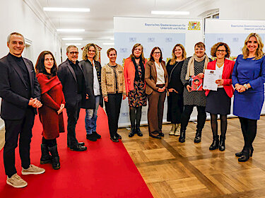 Gruppenbild, Schulleiterin de la Camp hält die Urkunde zur Auszeichnung Gruppenbild, Schulleiterin de la Camp hält die Urkunde zur Auszeichnung